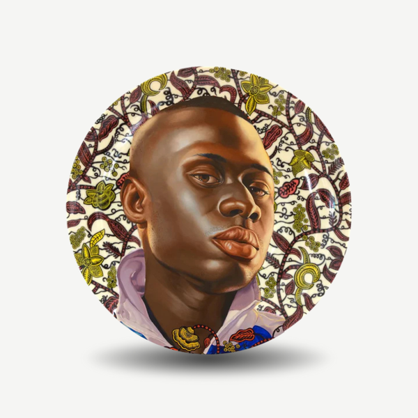 Decorative plate with a stylized portrait of a person surrounded by intricate patterns on a white background. Kehinde Wiley - Idrissa Plate