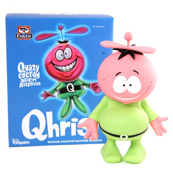 Toy figure of a pink alien with a green outfit next to its packaging