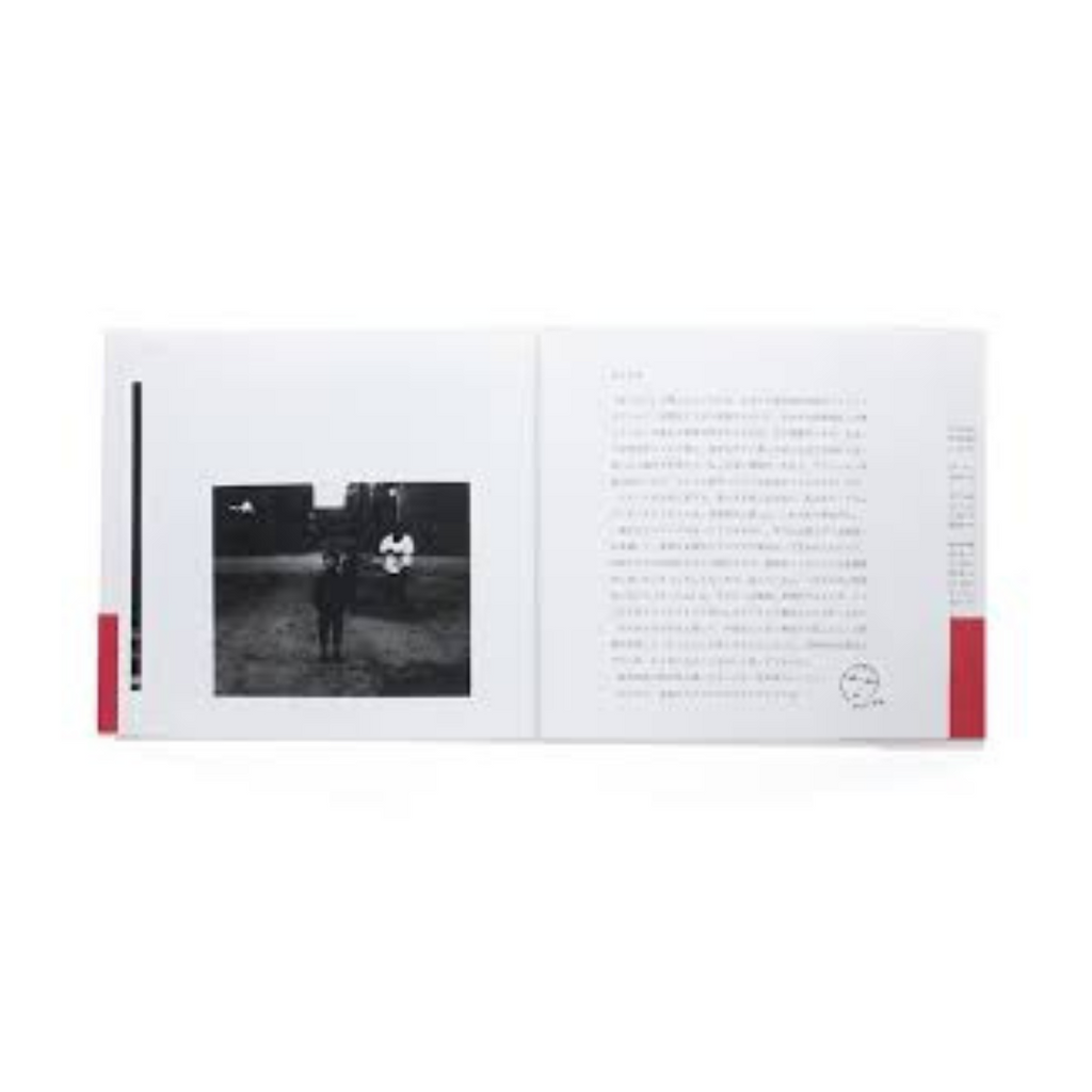 Open book with a black and white photo on the left page and text on the right page. with photos by Nobuyashi Araki of Japanese children at play.