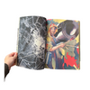 Open book showing a black and white abstract page and a colorful illustration of a person with tools.