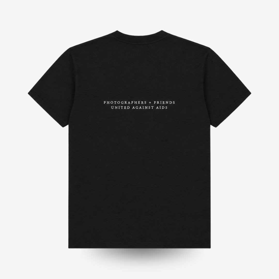 A black short-sleeve crewneck t-shirt with white text on the chest reading 'PHOTOGRAPHERS = FRIENDS UNITED AGAINST AIDS', displayed flat against a light gray background.