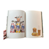 Open book showing illustrations of Frijol bottles and a cow figure on a white background