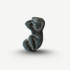 Black stone sculpture of a seated figure on a white background Amedeo Modigliani - Cariatide