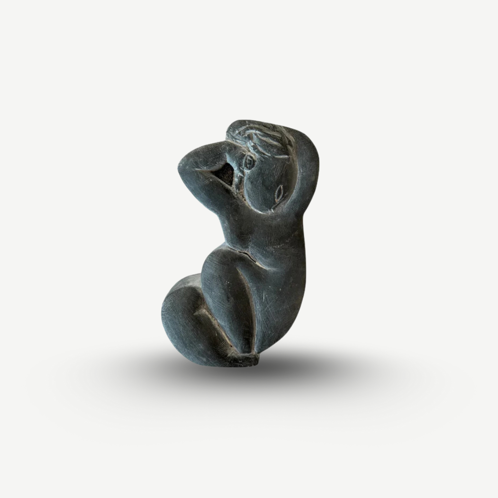 Black stone sculpture of a seated figure on a white background Amedeo Modigliani - Cariatide