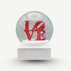 Snow globe with 'LOVE' text in red on a white background. Love by Robert Indiana official sculpture certified by the Morgan Art Foundation. Robert Indiana Collectible.